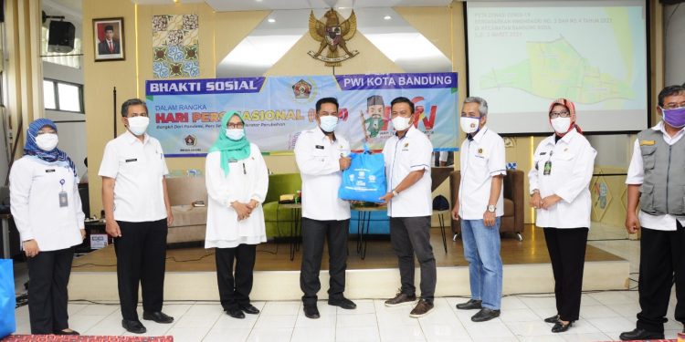 Secara simbolis, Ketua PWI Kota Bandung Hardiyansyah, menyerahkan bantuan sembako kepada Camat Bandung Kidul Evi Hendarin, Selasa (3/3/2021)