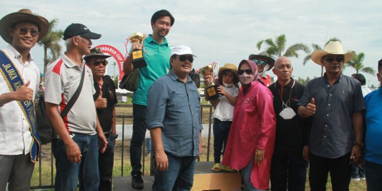 Teks foto: Bupati Pangandaran, H. Jeje Wiradinata menyerahkan piala atas keberhasilan kuda Darmaraja memenangi Kelas 3 Tahun Derby 1550 meter. (Doc).