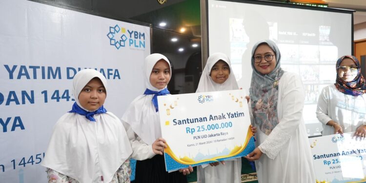 SIMBOLIS-Ketua Persatuan Ibu, Karyawan dan Karyawati (PIKK) PLN UID Jakarta Raya, Sri Murniatiningrum Lasiran, menyerahkan santunan secara simbolis kepada adik-adik perwakilan Yayasan Masjid Nurul Mujahidin. (Foto Ist).