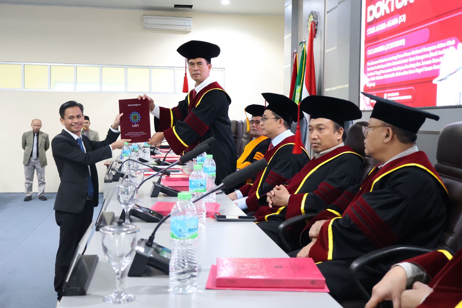 Dr.Caca Handika, berfoto bersama dengan tim promotor dan tim penguji saat menerima Setifikat Kelulusan Sidang Terbuka Program Doktoral di Pascasarjana UIN SGD Bandung, Kamis,14 Agustus 2025/bedanews.com