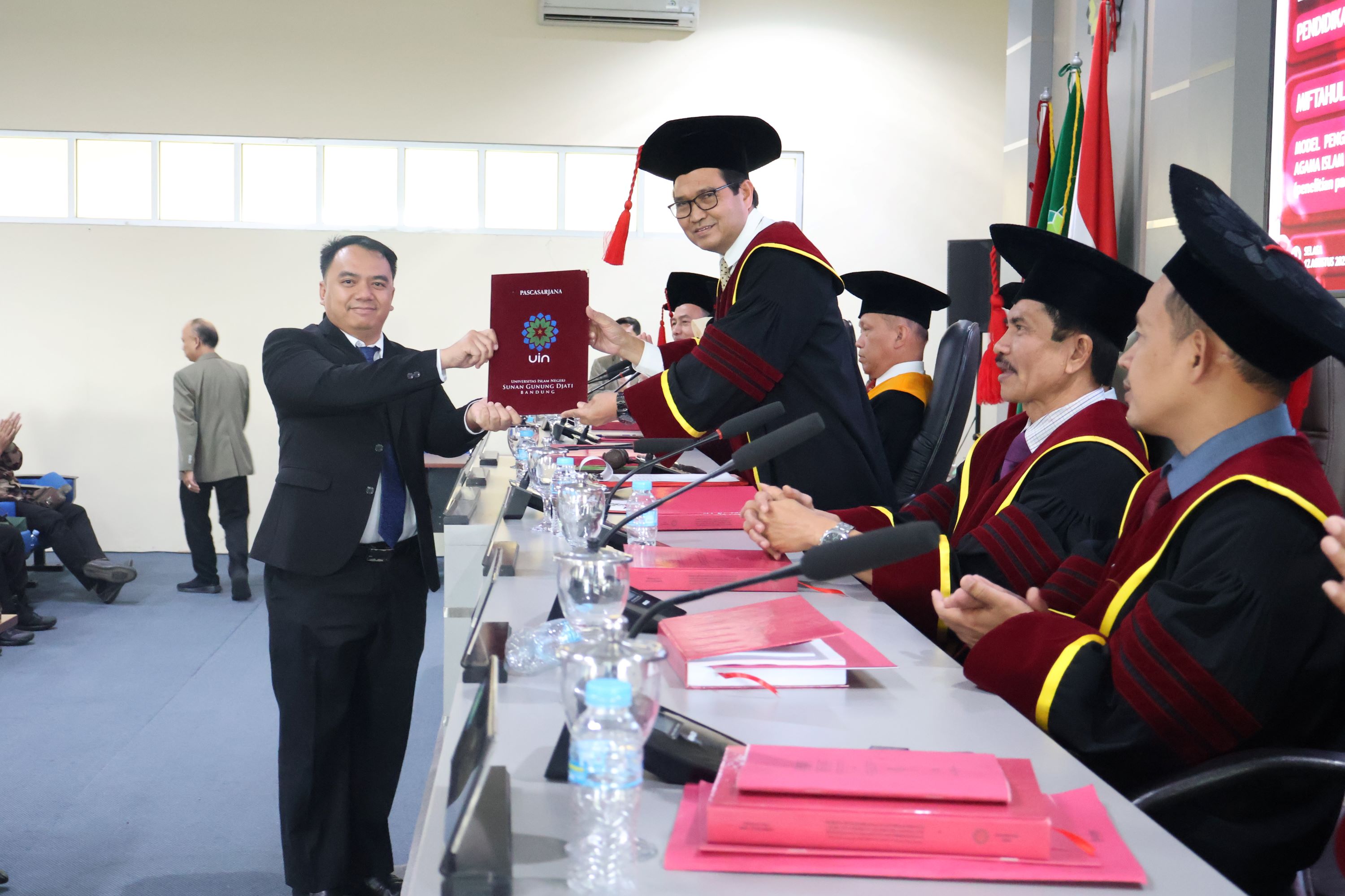 Dr.Miftahul Fikri saat menerima sertifikat Kelulusan dalam sidang terbuka program doktoral pascasarjana UIN SGD Bandung. Rabu,(13/08)/dedy brajamusti/bedanews.com
