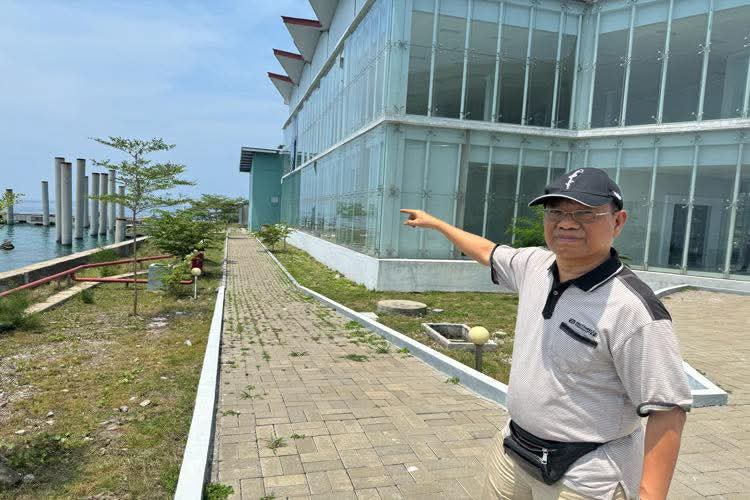 TERBENGKALAI-Sugiyanto (SGY) – Emik, saat menunjuk dermaga yang diduga dikerjakan oleh Dinas Perhubungan DKI Jakarta, namun terbengkalai di depan Kantor Bupati Kepulauan Seribu. (Foto Ist).