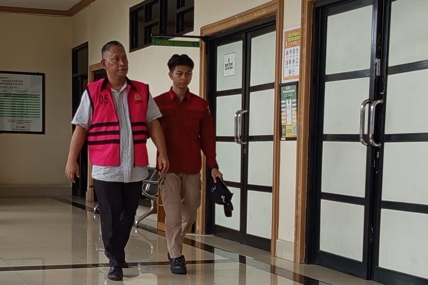 Terdakwa Sutikno (Rompi Merah Muda) menuju ruang sidang. (Foto Ist).