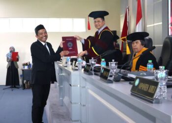 FOTO: Ridwan Mustopa saat menerima sertifikat kelulusan dari ketua sidang usai meraih gelar doktor di UIN SGD Bandung,Jumat,(28/8/2026)/bedanews.com/Brajamusti