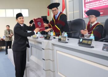 FOTO : Iip Miptahudin saat menerima sertifikat dari ketua sidang usai meraih gelar doktor di pascasarjana UIN SGD Bandung/Kamis,(13/8/2026)/bedanews.com/brajamusti